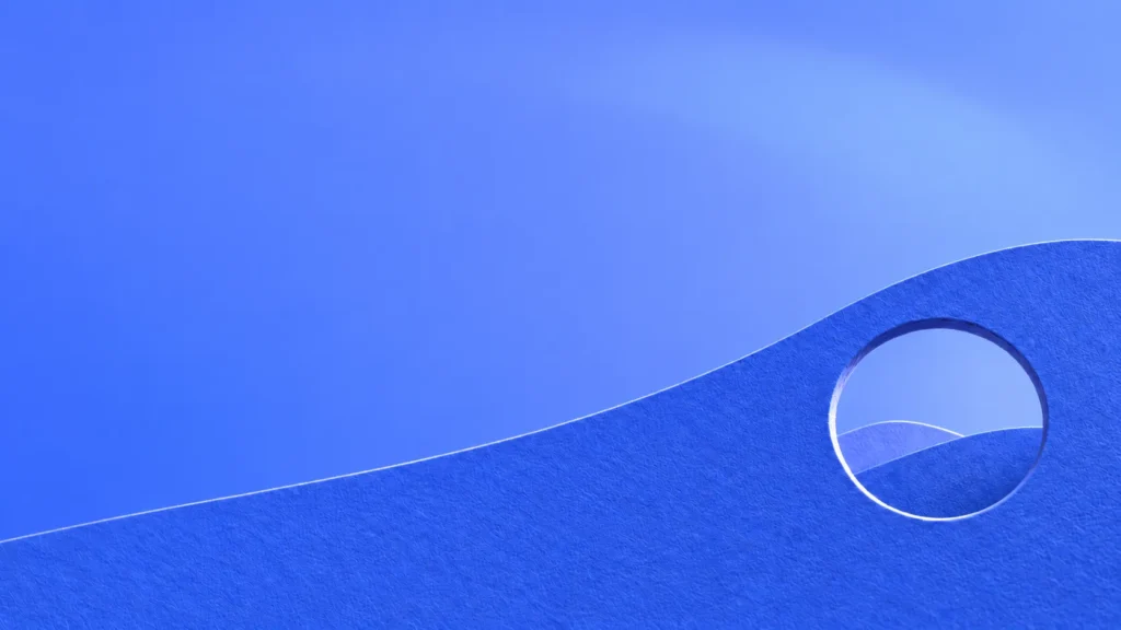 Recorte circular em papel azul revelando colinas